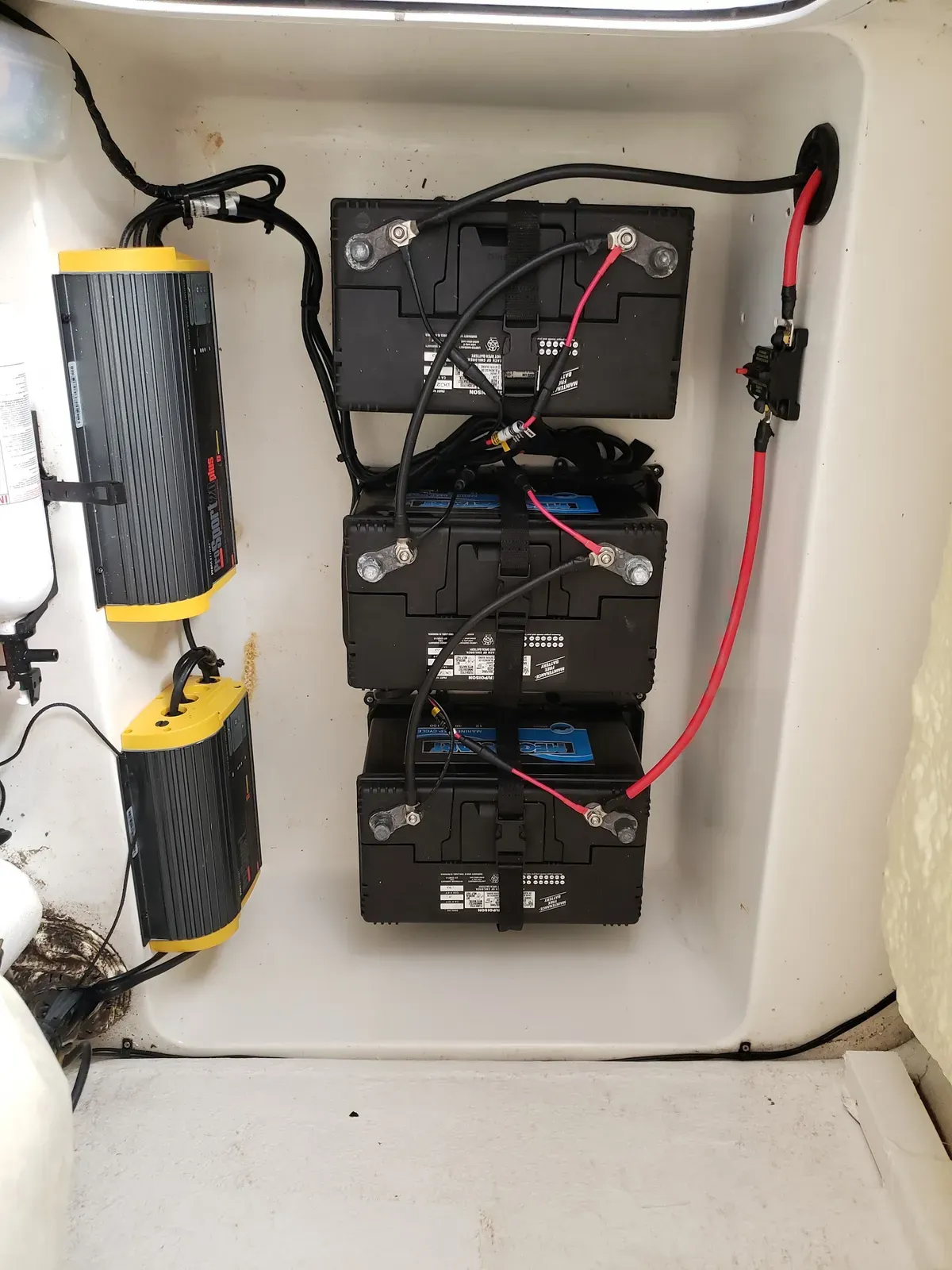 Neatly wired three-battery bank with onboard charger in a console
