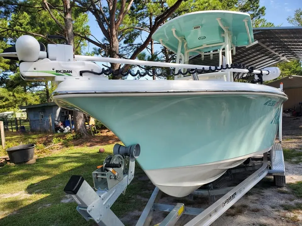 Seafoam center console with a bow-mounted trolling motor on its trailer at the Action Marine shop