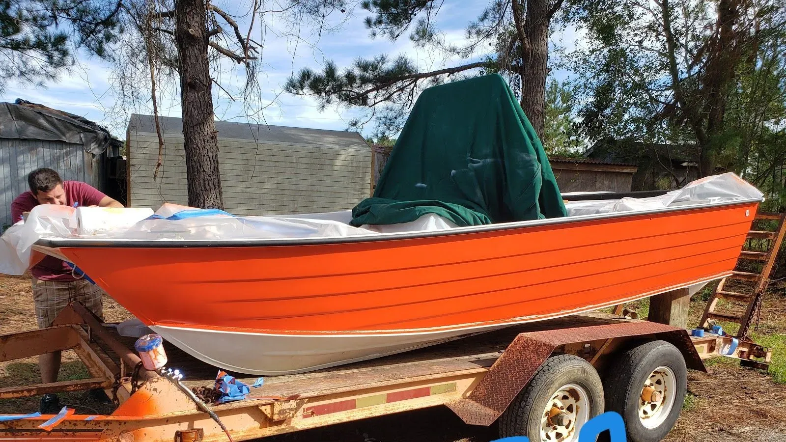 Freshly refinished orange skiff on a trailer