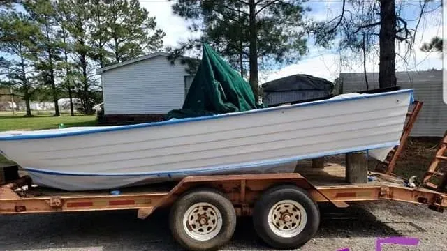 The skiff before: plain white hull on a trailer